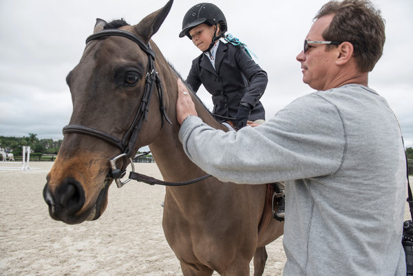 Sienna Pilla, 9, and her father, Philip, travel to Florida from their home in Ridgefield, Conn., on weekends so that she can compete in the Winter Equestrian Festival. Credit Josh Ritchie for The New York Times